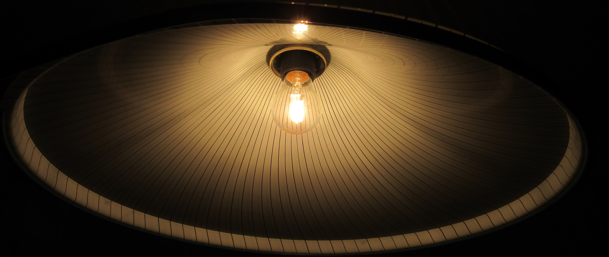 Lampenschirm mit leuchtender Glühlampe.