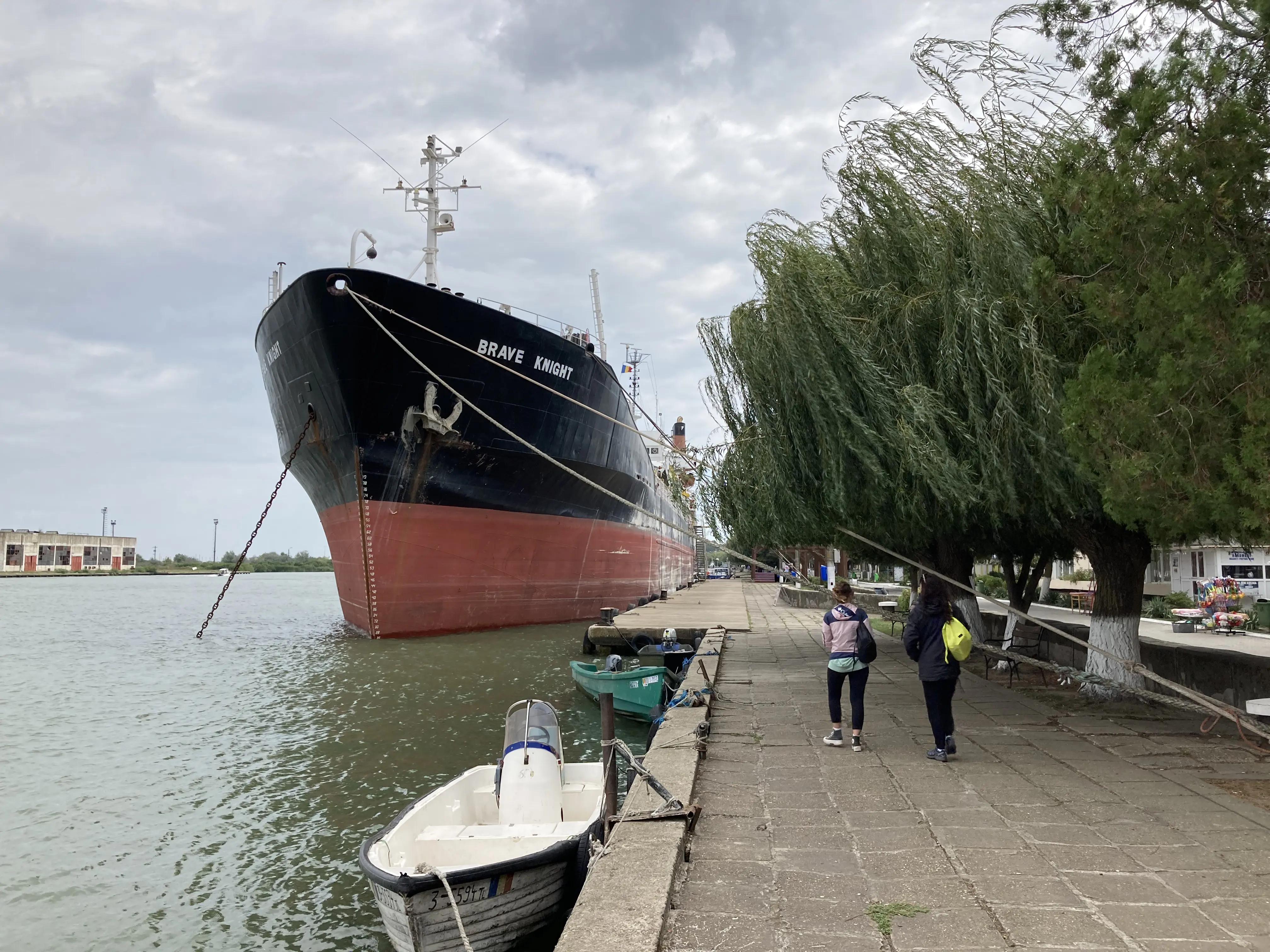 Farbfoto: Hafen mit sehr hohem Schiff vor Anker.