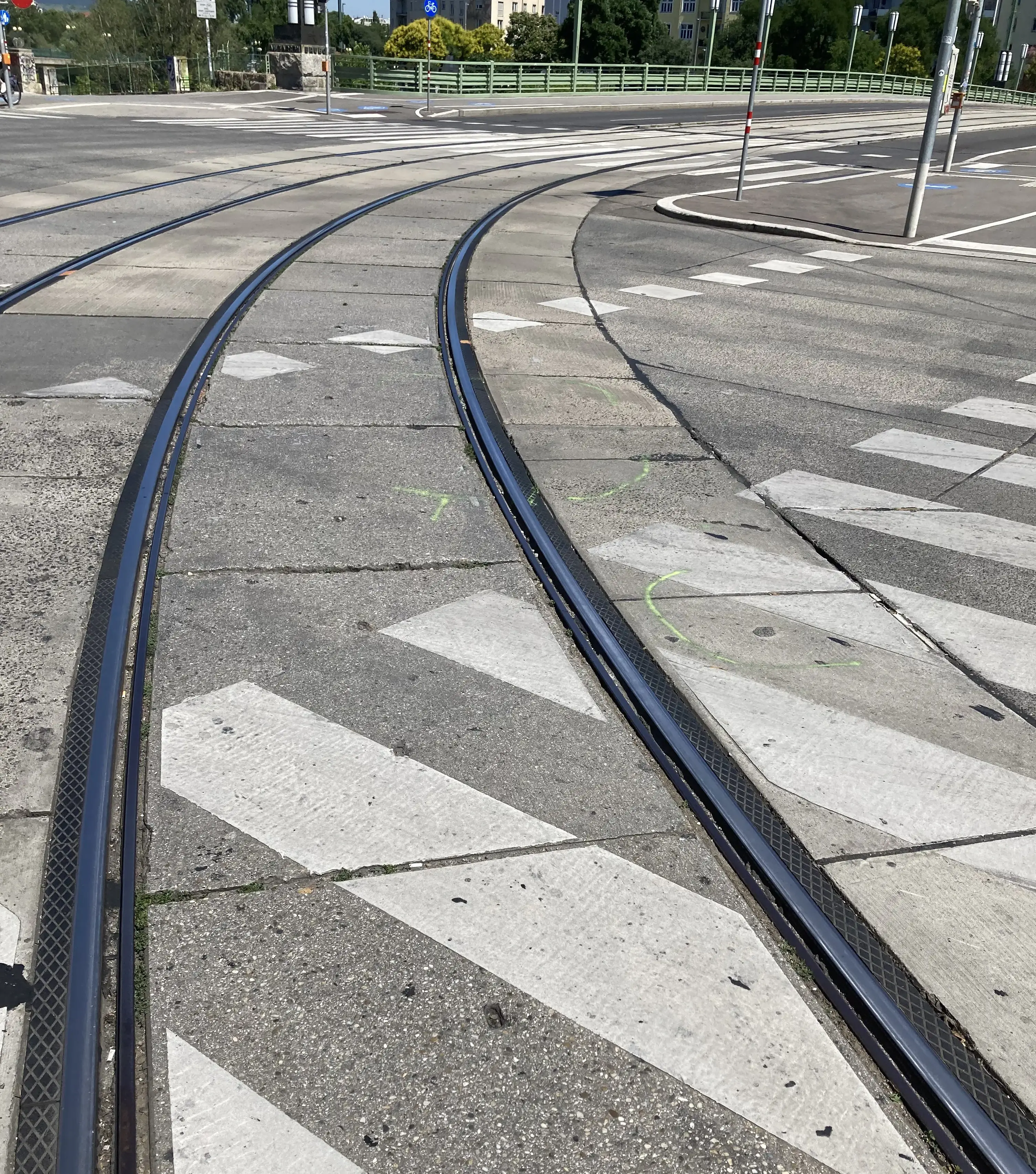 Farbfoto: Straßenbahngleise in einer Kurve, daneben grüne Sprühmarkierungen auf den Betonplatten